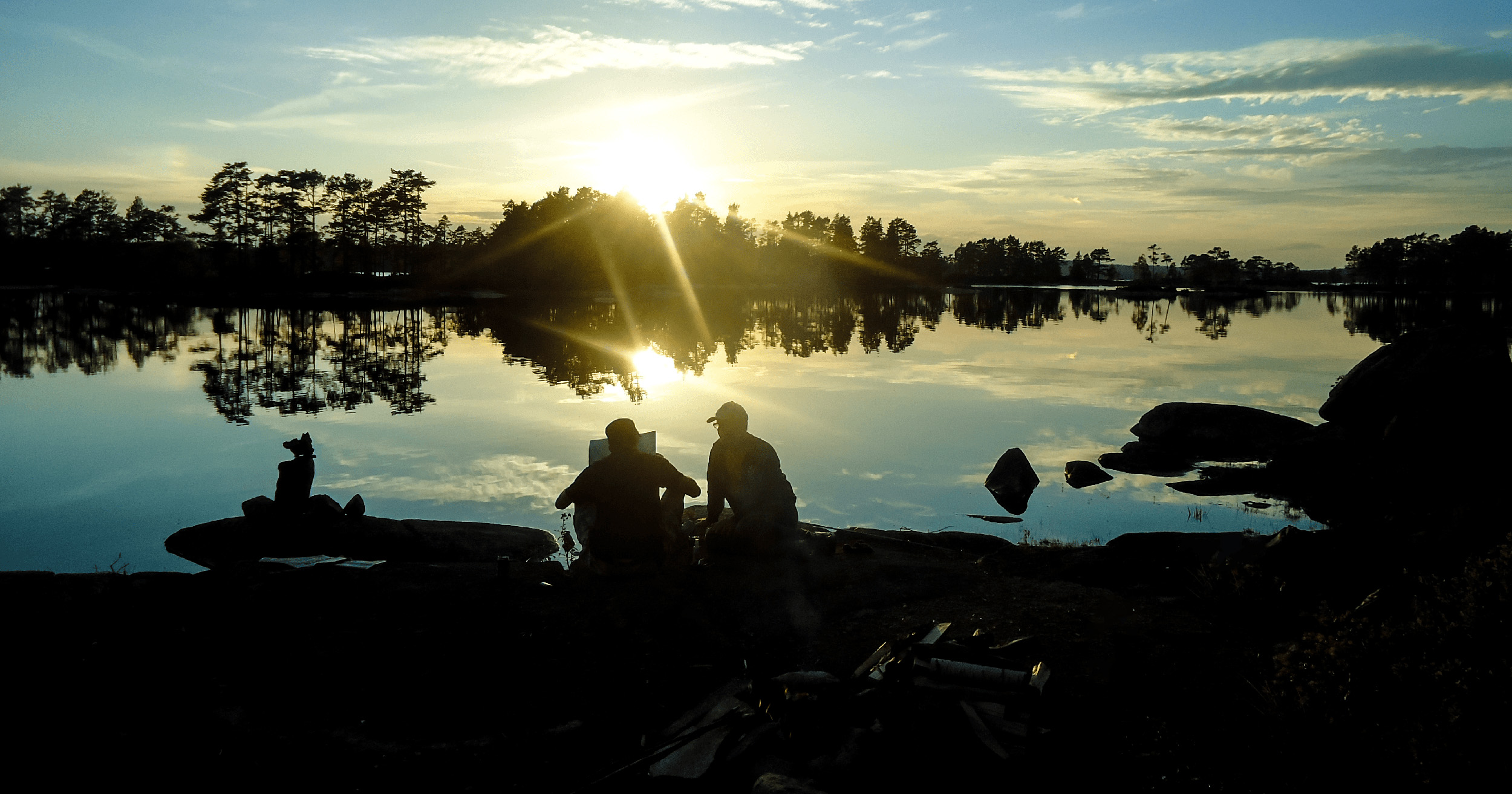Läser karta vid sjö i solnedgång